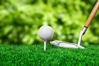 Image of Golf ball on green grass and club outdoors, closeup