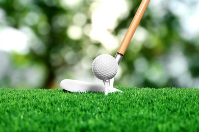 Image of Golf ball on green grass and club outdoors, closeup