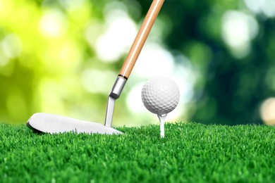 Image of Golf ball on green grass and club outdoors, closeup