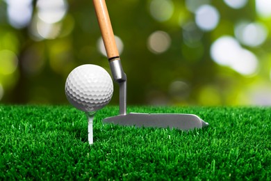 Image of Golf ball on green grass and club outdoors, closeup