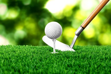 Image of Golf ball on green grass and club outdoors, closeup