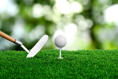 Image of Golf ball on green grass and club outdoors, closeup