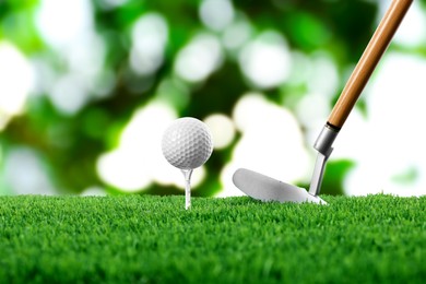 Image of Golf ball on green grass and club outdoors, closeup