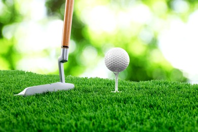 Image of Golf ball on green grass and club outdoors, closeup