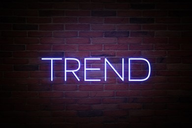 Image of Neon sign with word Trend on brick wall