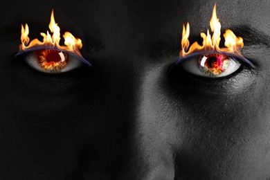 Image of Man with fire burning in his eyes, closeup. Black and white effect