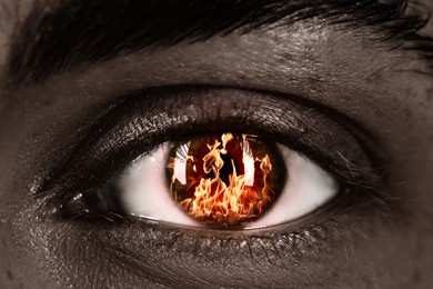 Image of Woman with fire burning in her eye, closeup