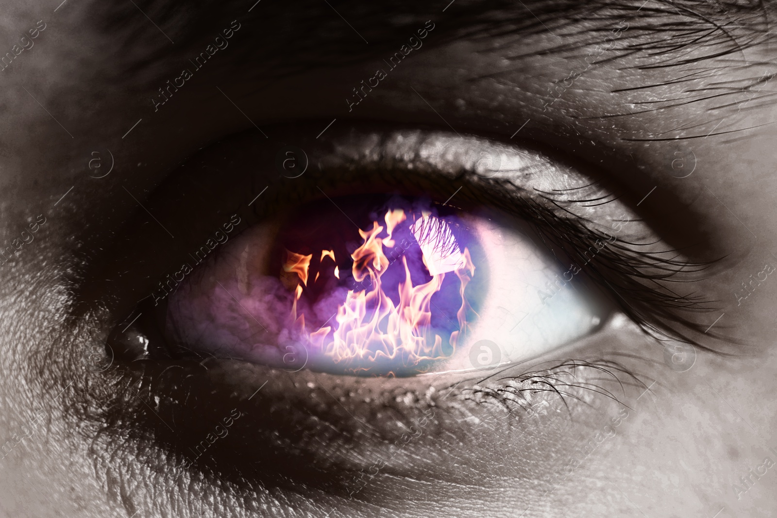 Man with fire burning in his eye, closeup. Black and white effect Image of Man with fire burning in his eye, closeup. Black and white effect