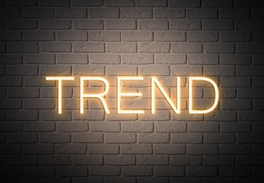 Image of Neon sign with word Trend on brick wall