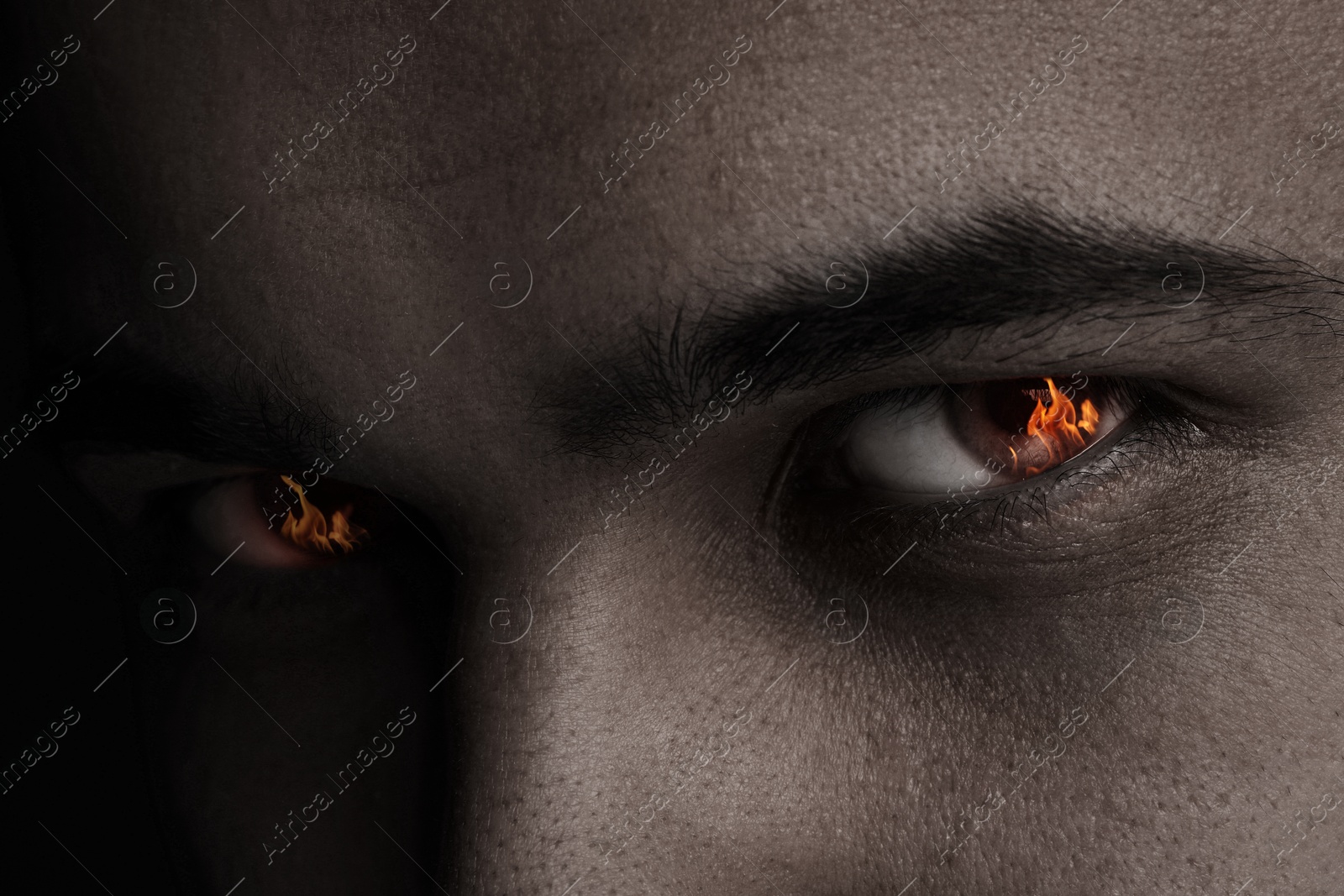 Man with fire burning in his eyes, closeup Image of Man with fire burning in his eyes, closeup