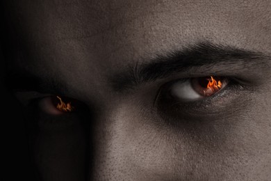 Image of Man with fire burning in his eyes, closeup