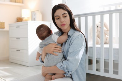 Photo of Woman suffering from postpartum depression with her little baby at home