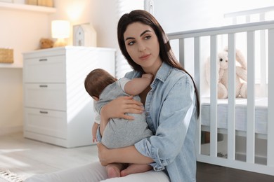 Photo of Woman suffering from postpartum depression with her little baby at home