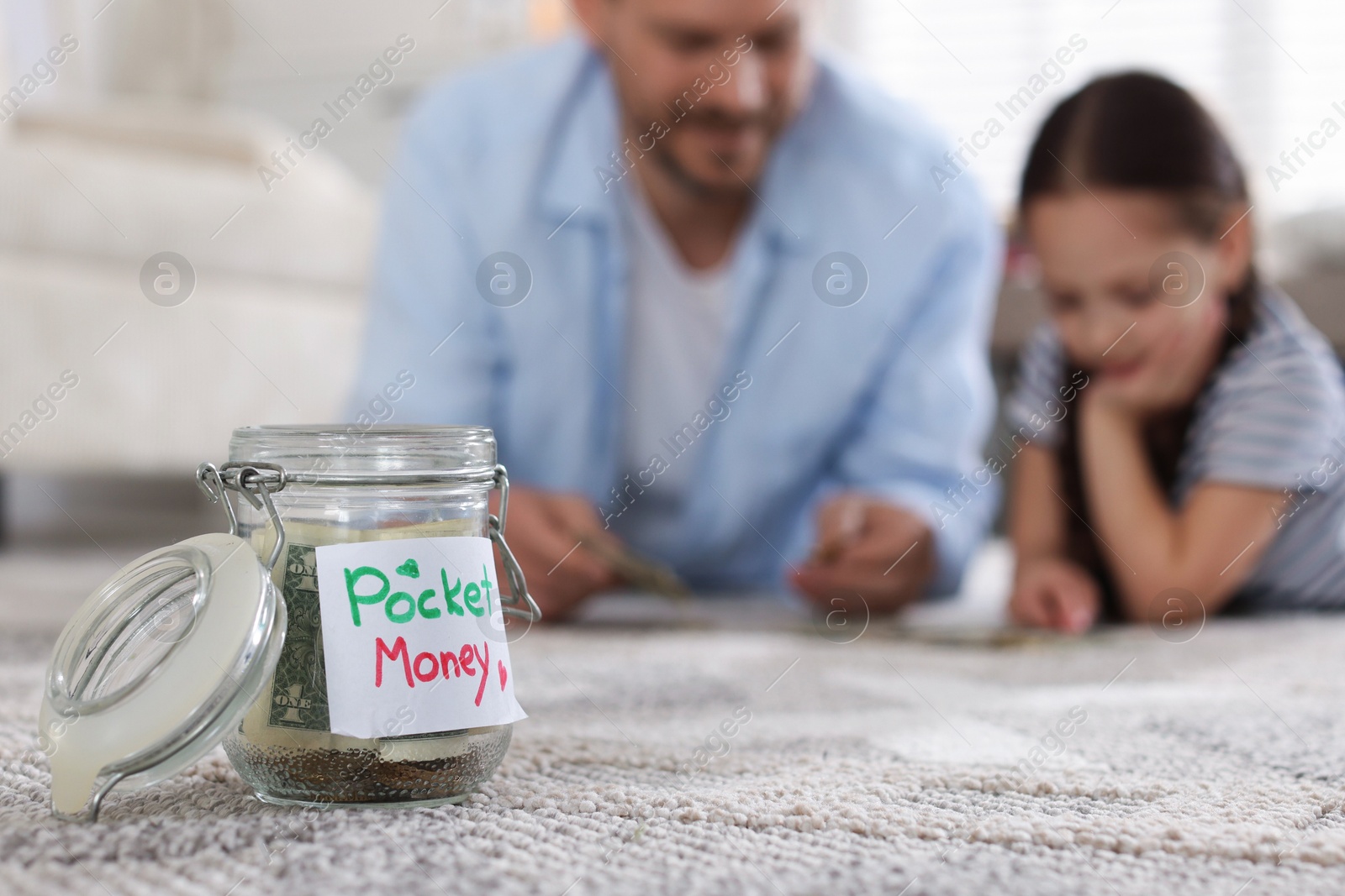 Jar with pocket money, father and daughter at home, selective focus Photo of Jar with pocket money, father and daughter at home, selective focus
