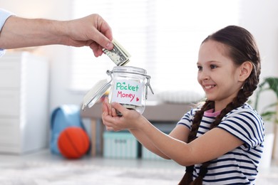 Photo of Father giving his daughter pocket money at home, closeup