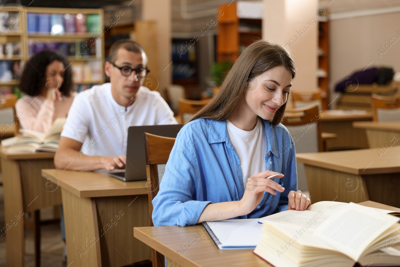 People studying at desks in public library, selective focus Photo of People studying at desks in public library, selective focus