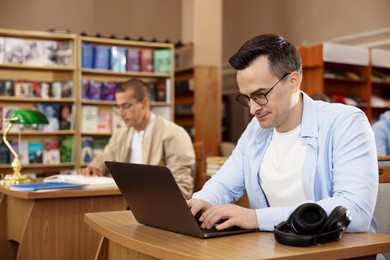 Photo of People studying at desks in public library, selective focus