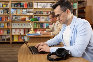 Photo of People studying at desks in public library, selective focus