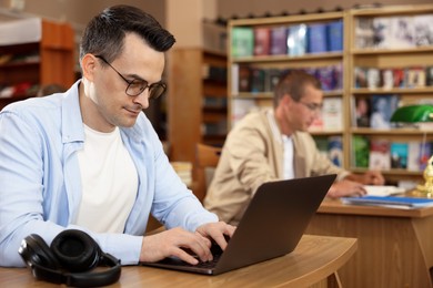 Photo of People studying at desks in public library, selective focus