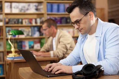 Photo of People studying at desks in public library, selective focus