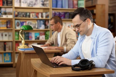 Photo of People studying at desks in public library, selective focus