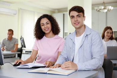Photo of People studying together at desk in library, selective focus