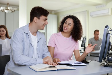 Photo of People studying together at desk in library, selective focus