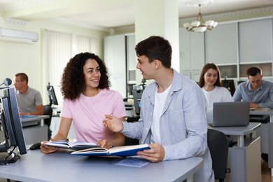 Photo of People studying together at desk in library, selective focus