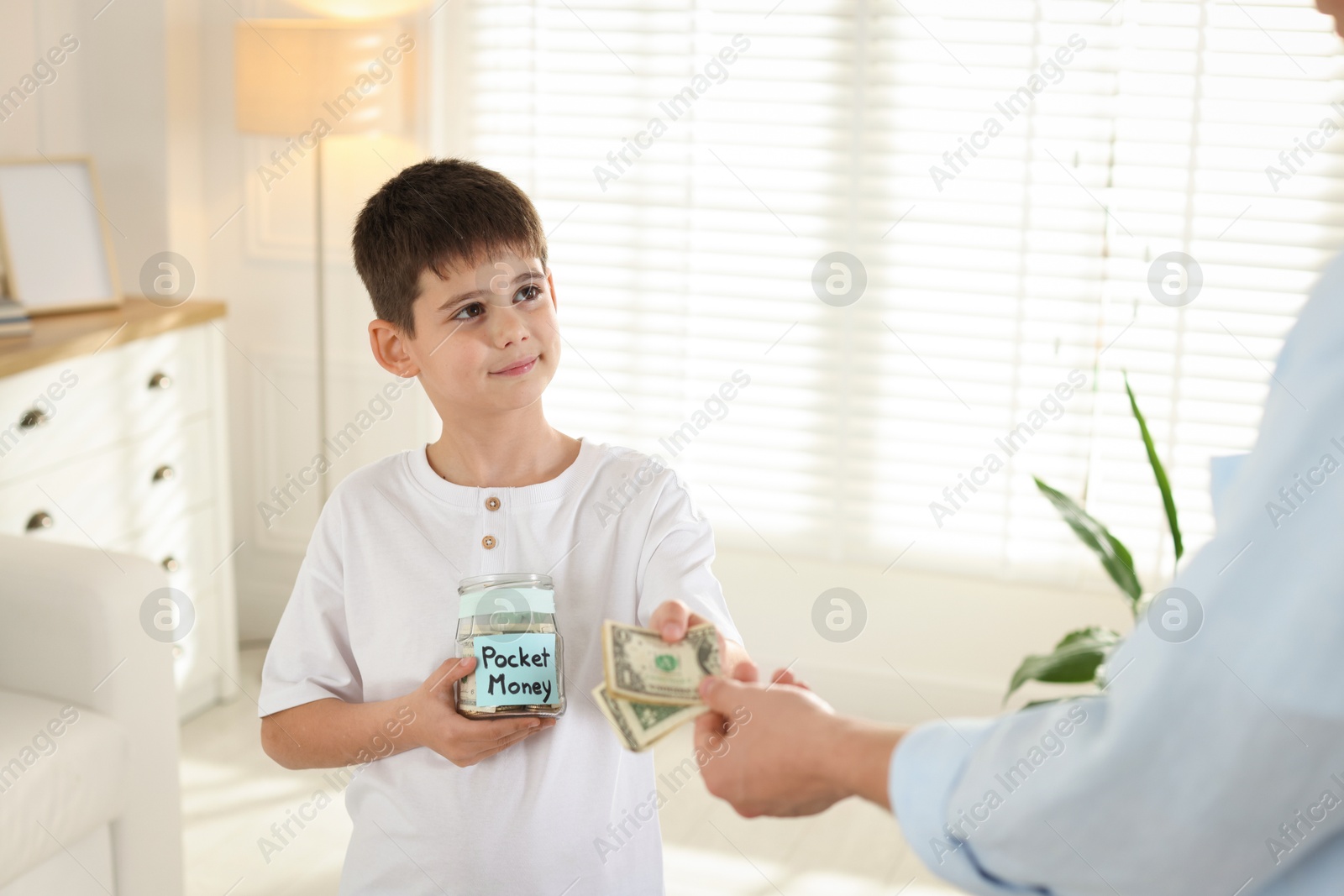 Father giving his son pocket money at home, closeup Photo of Father giving his son pocket money at home, closeup