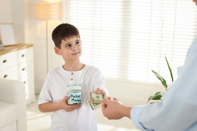 Photo of Father giving his son pocket money at home, closeup