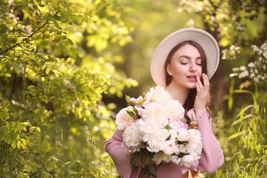 Photo of Beautiful woman with bouquet of peonies in park. Space for text