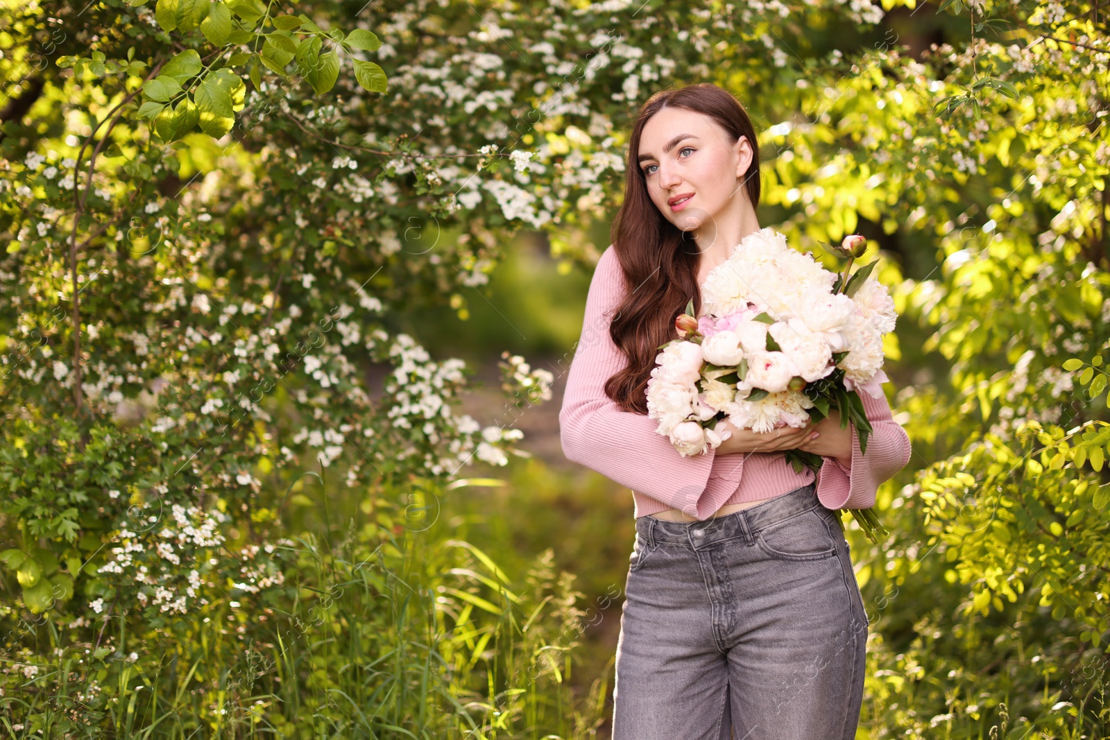 Beautiful woman with bouquet of peonies in park. Space for text Photo of Beautiful woman with bouquet of peonies in park. Space for text