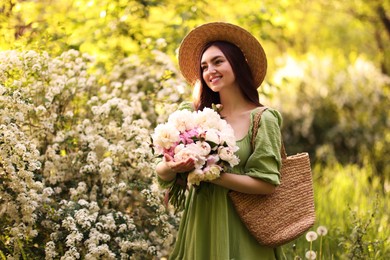 Photo of Beautiful woman with bouquet of peonies in park