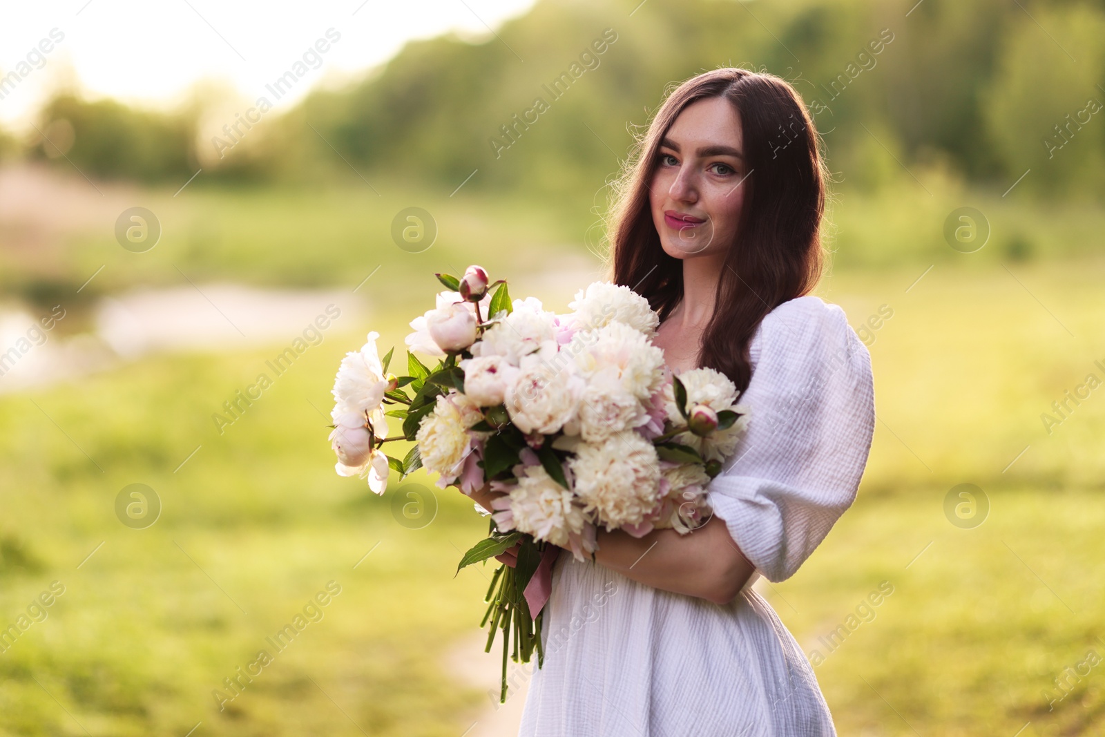 Beautiful woman with bouquet of peonies in park. Space for text Photo of Beautiful woman with bouquet of peonies in park. Space for text