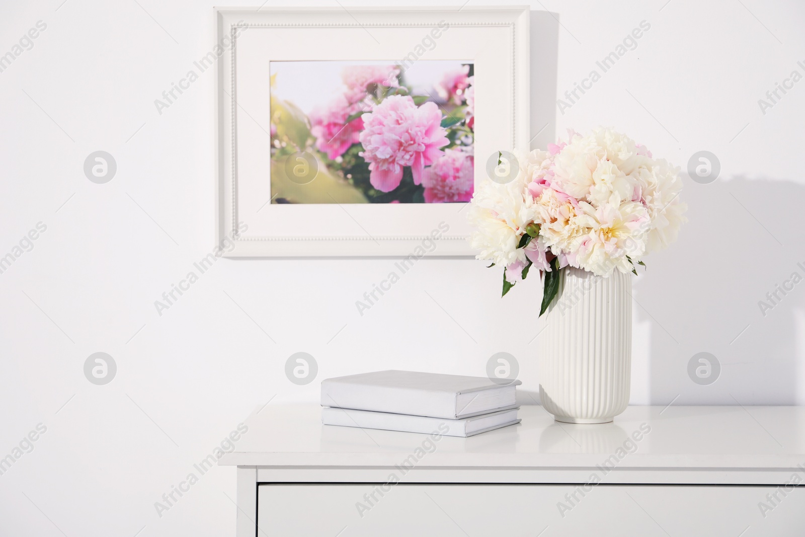 Bouquet of beautiful peonies and books on table indoors Photo of Bouquet of beautiful peonies and books on table indoors