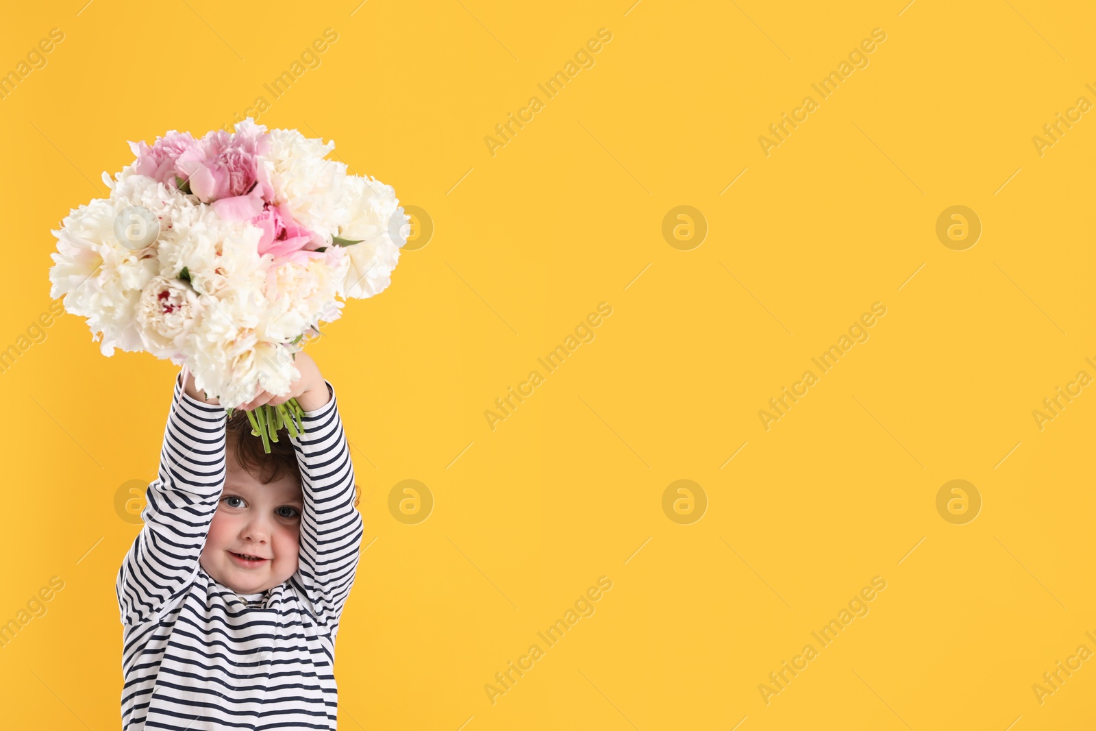 Cute little boy with bouquet of beautiful peonies on yellow background. Space for text Photo of Cute little boy with bouquet of beautiful peonies on yellow background. Space for text