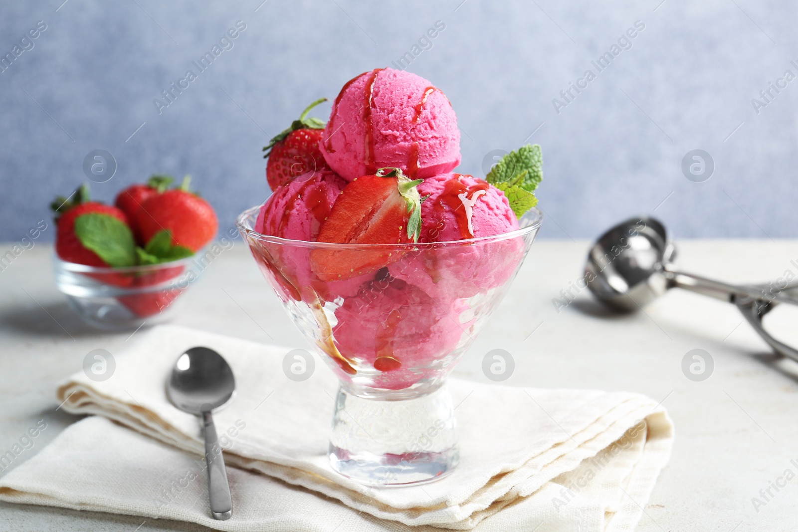 Tasty sorbet with strawberries and mint served on light table Photo of Tasty sorbet with strawberries and mint served on light table