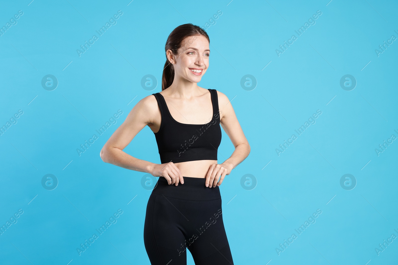 Photo of Beautiful woman with flat belly on light blue background
