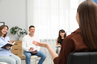 Photo of Group of people having meeting during life coaching class indoors, selective focus