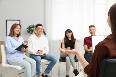 Photo of Group of people having meeting during life coaching class indoors, selective focus