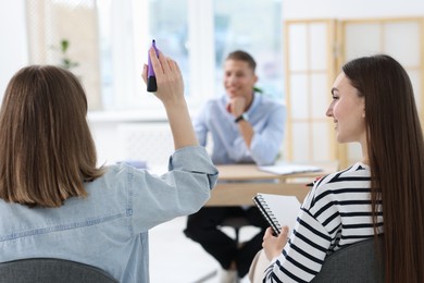 Photo of Group of people having meeting during life coaching class indoors, selective focus