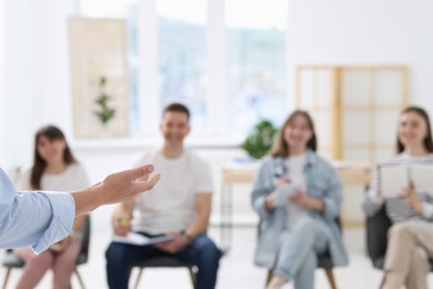 Photo of Group of people having meeting during life coaching class indoors, selective focus