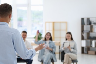 Photo of Group of people having meeting during life coaching class indoors, selective focus