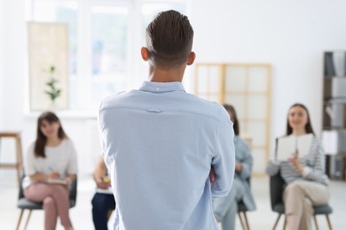 Photo of Group of people having meeting during life coaching class indoors, selective focus