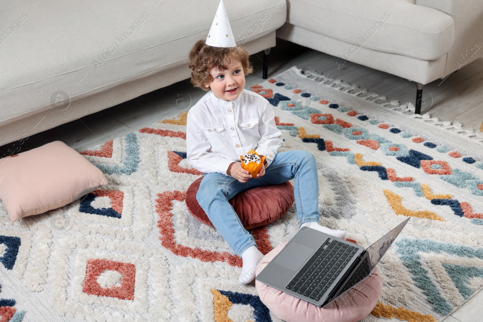 Birthday celebration. Little boy with cupcake having video call via laptop at home Photo of Birthday celebration. Little boy with cupcake having video call via laptop at home