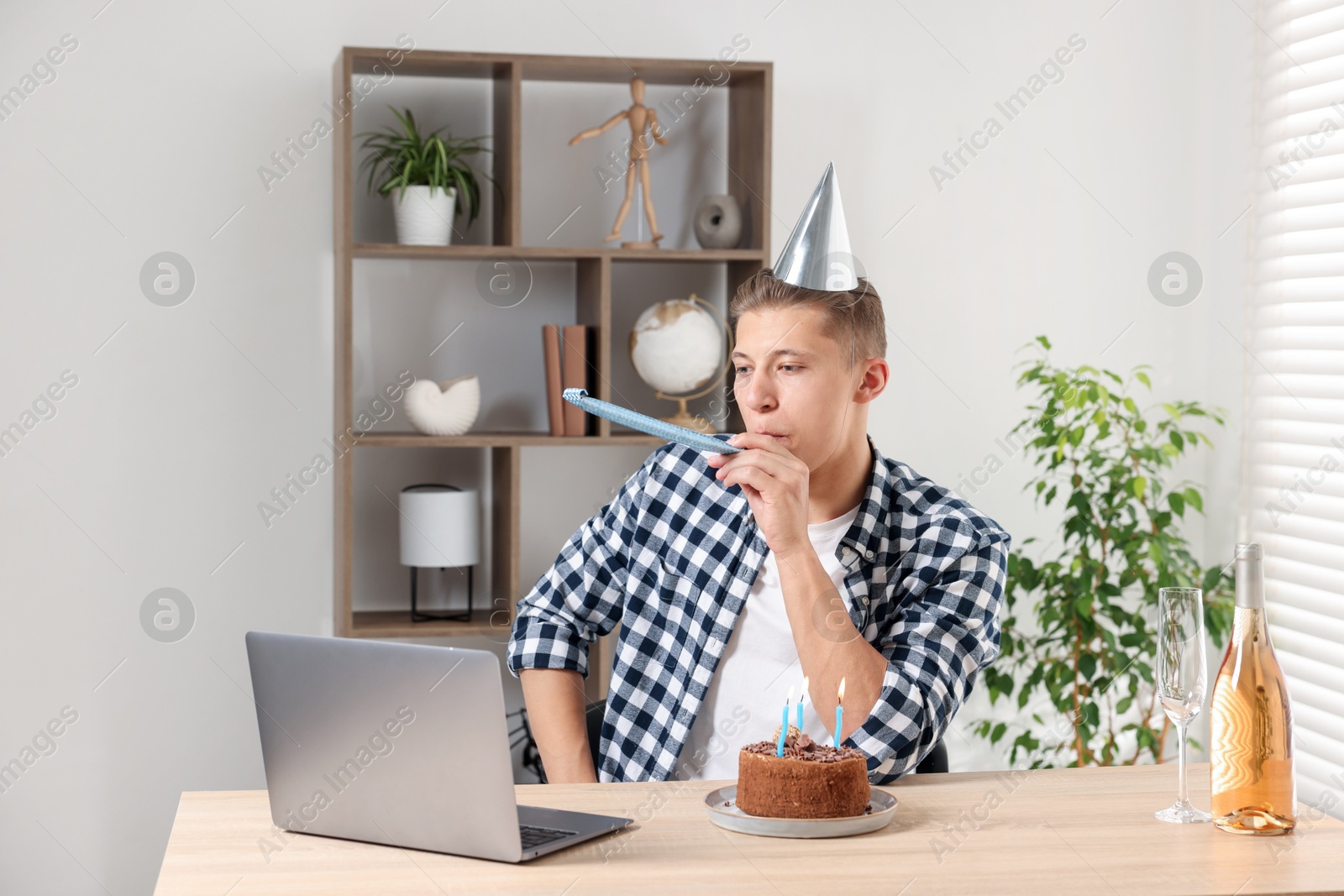 Photo of Happy man celebrating his birthday while having video call at desk indoors