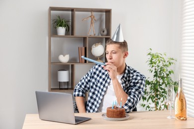 Photo of Happy man celebrating his birthday while having video call at desk indoors