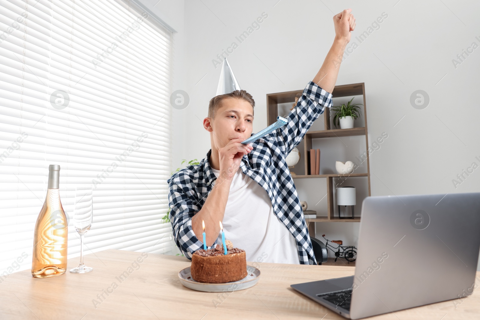 Photo of Happy man celebrating his birthday while having video call at desk indoors