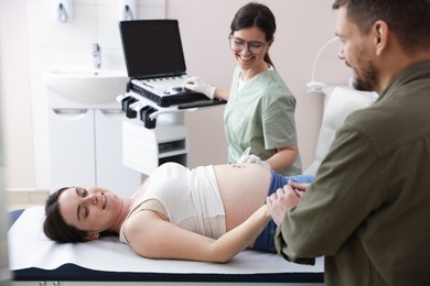 Photo of Woman and her husband attending prenatal ultrasound examination in clinic