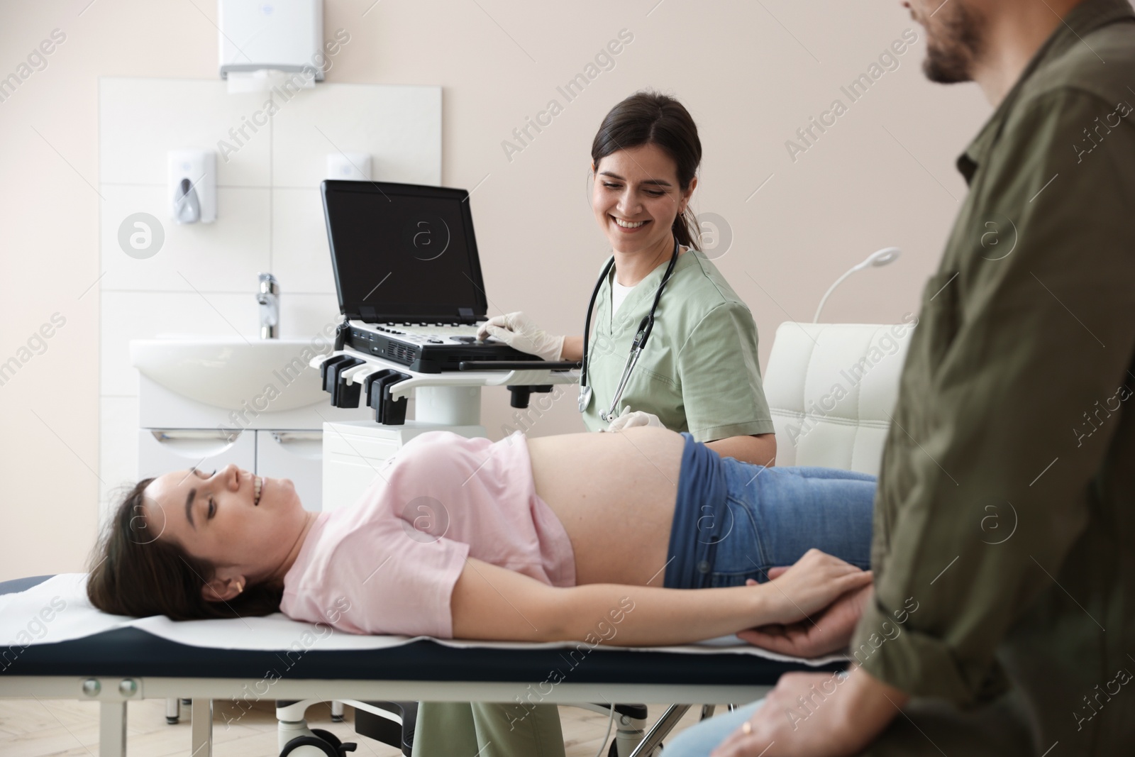 Photo of Woman and her husband attending prenatal ultrasound examination in clinic